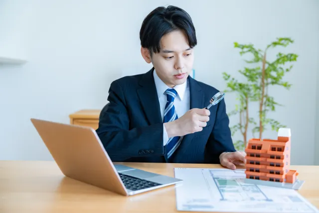 門真市の建物外観を確認し、屋根点検の方法を判断しているイメージ